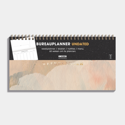 Bureauplanner undated met een design van verfstreken in warme aardetinten, harde cover en metalen ringband – vooraanzicht met informatieve banderol.