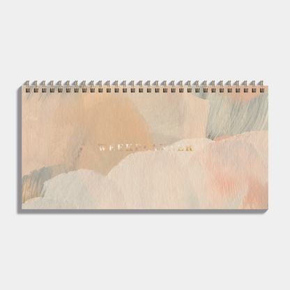 Bureauplanner undated met een design van verfstreken in warme aardetinten, harde cover en metalen ringband – vooraanzicht.