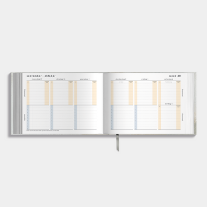 Studieplanner 2025-2026 A5 met design van grijsgroene verfstreken – binnenwerk met weekoverzicht.