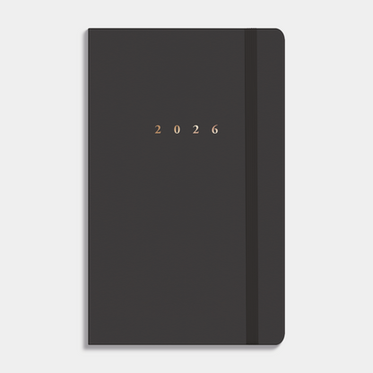 A6 agenda 2026 met suèdelook cover in antraciet, harde cover en stevige elastieken sluiting – vooraanzicht.